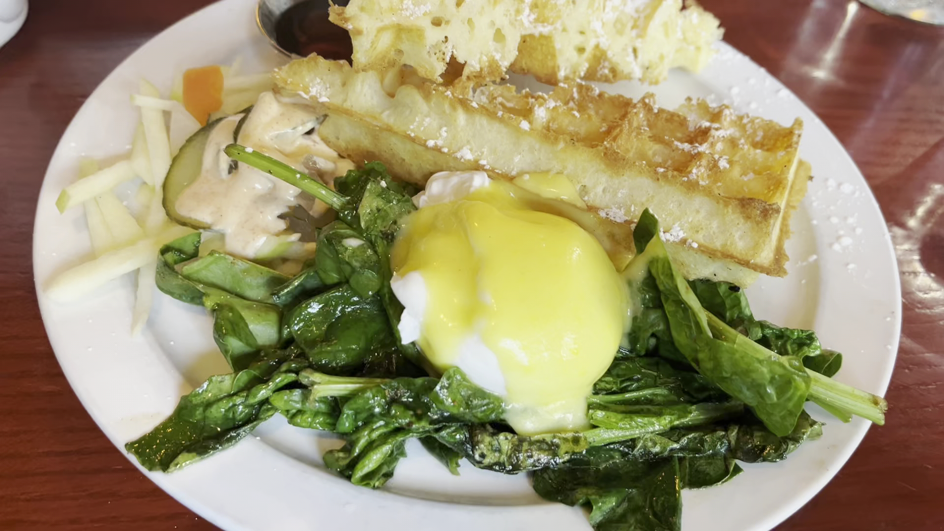 Waffle Benny with poached eggs, hollandaise, and spinach on Belgian waffle at Petit Dejeuner