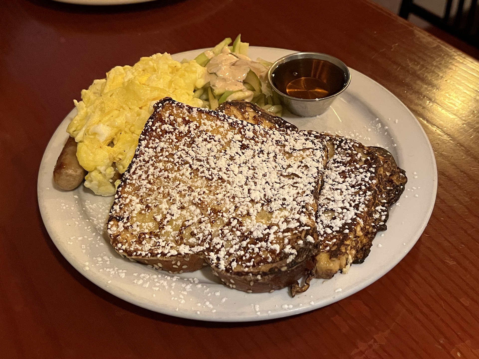 French toast with eggs, sausage, fruit, and maple syrup at Petit Dejeuner Toronto