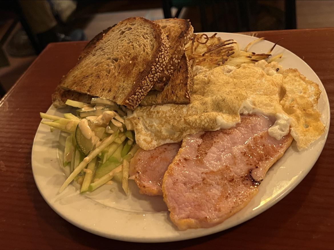 Full breakfast plate with eggs, ham, toast, hash browns and salad